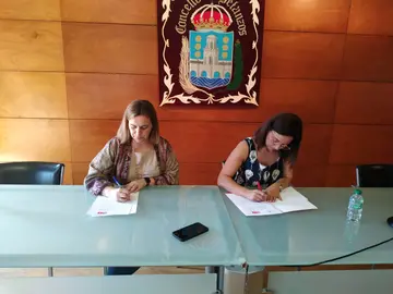 Amelia S&aacute;nchez e Mar&iacute;a Barral asinando o acordo de investidura