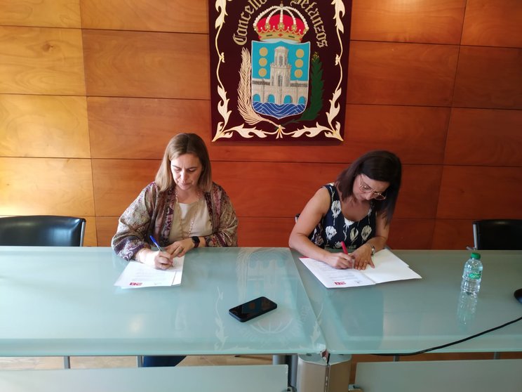 Amelia Sánchez e María Barral asinando o acordo de investidura