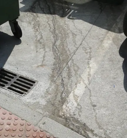 Marcas de augas residuais ao p&eacute; dun colector do lixo
