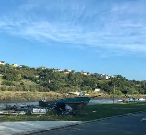 Restos de lixo e embarcaci&oacute;ns no porto