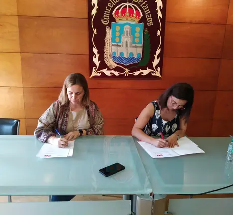 Amelia S&aacute;nchez e Mar&iacute;a Barral asinando o acordo de investidura